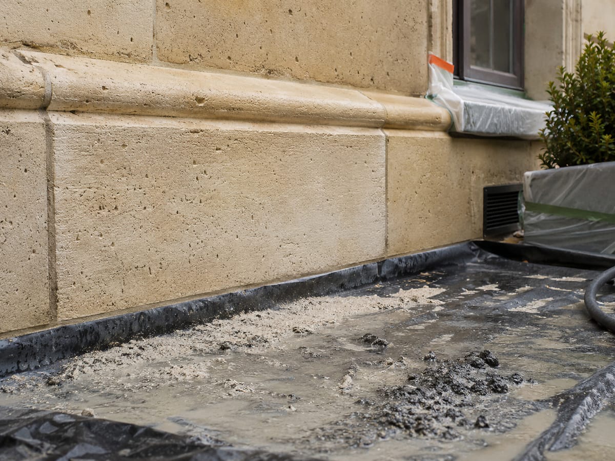 Résidus humides et microgranulats après hydrogommage d’une façade en pierre