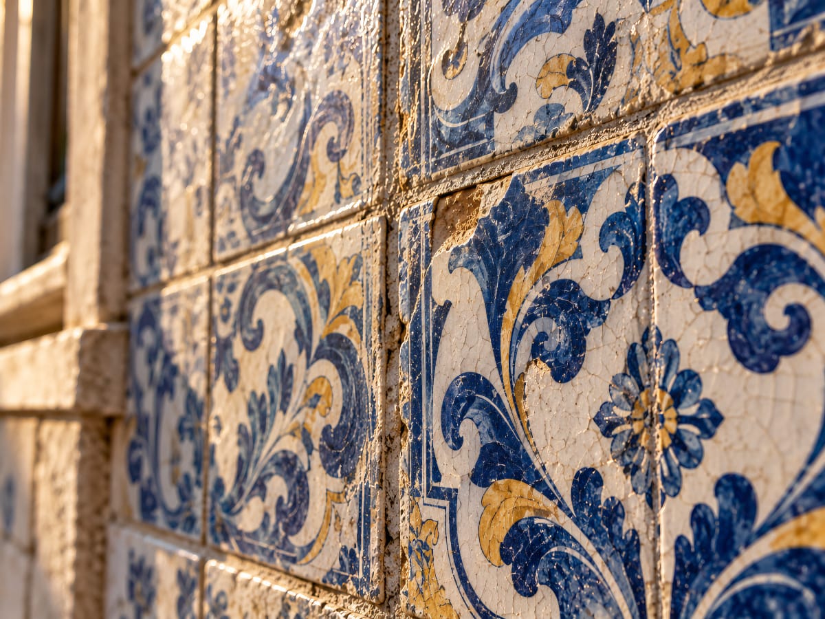 Gros plan d’azulejos anciens avec glaçure patinée, joints irréguliers et petites fissures